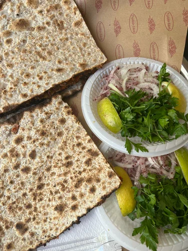 Bostancı Antep Kuzu Lahmacun’da katlanmış lahmacunlar, soğan, maydanoz ve limon