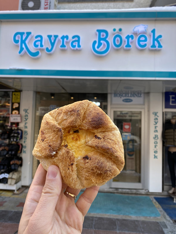 Kayra Börek dükkânı önünde elde tutulan ağzı açık böreği