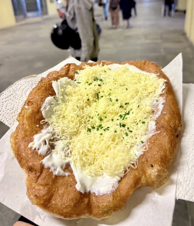 Flórián téri Krumplis Lángos’un ekşi krema ve rendelenmiş peynirle servis edilen lángosu