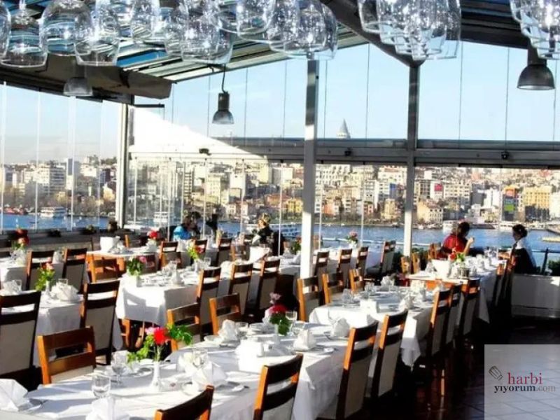 Hamdi Restaurant, Eminönü'nde Haliç manzaralı geniş pencerelere sahip modern ve ferah bir restoran. Beyaz masa örtüleriyle düzenlenmiş şık masalar ve Boğaz manzarasıyla, geleneksel Türk mutfağını romantik bir atmosferde sunuyor. Galata Kulesi'nin görüldüğü bu manzara, misafirlere İstanbul'un büyüleyici atmosferini yaşatıyor.