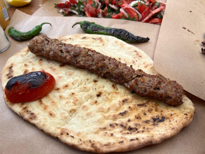 Kasap Selçuk Usta’da pide üzerinde kıyma kebabı, közlenmiş domates ve biber