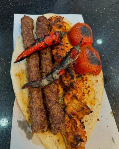 Kebapçı Ömer’de pide üzerinde kebaplar, közlenmiş domates ve biber