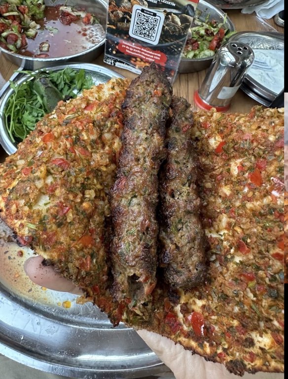 Küşlemeci Mehmet Usta’da lahmacun arasında kebap ve sofradaki salatalar