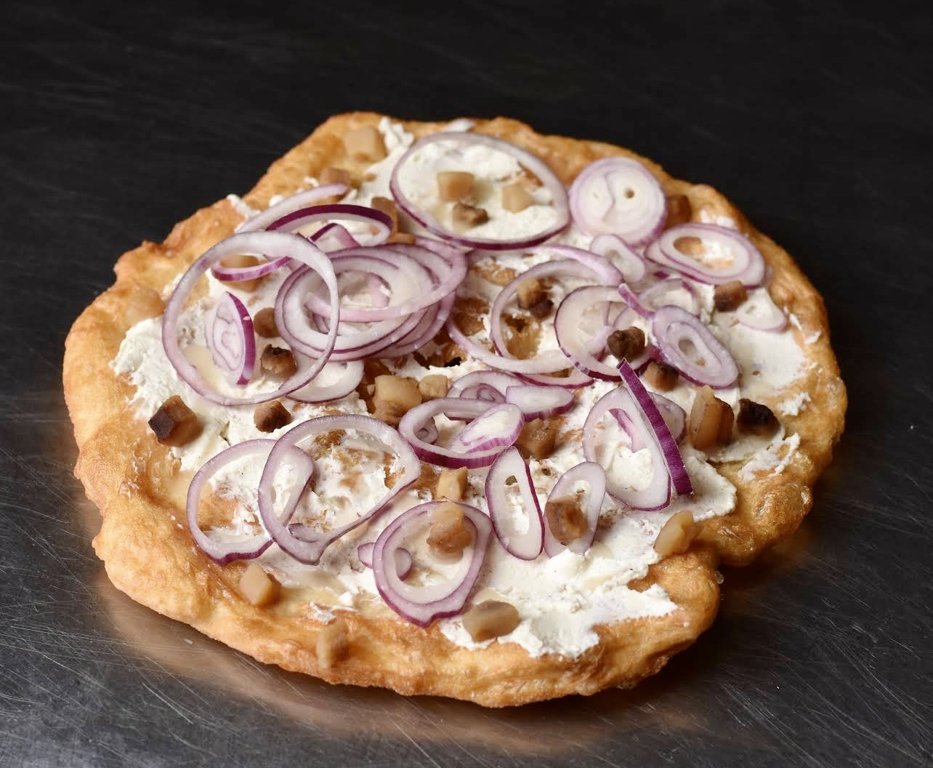 Ligeti Lángos’un kırmızı soğan halkalarıyla servis edilen lángosu