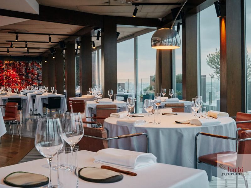 Mikla Restaurant, Beyoğlu'nda modern ve sofistike bir atmosfer sunuyor. Şık dekorasyonu, geniş pencereleri ve İstanbul'un panoramik manzarası ile dikkat çekiyor. Beyaz örtülerle hazırlanmış zarif masa düzeni, romantik ve özel günlerde unutulmaz bir akşam yemeği için ideal bir ortam yaratıyor.